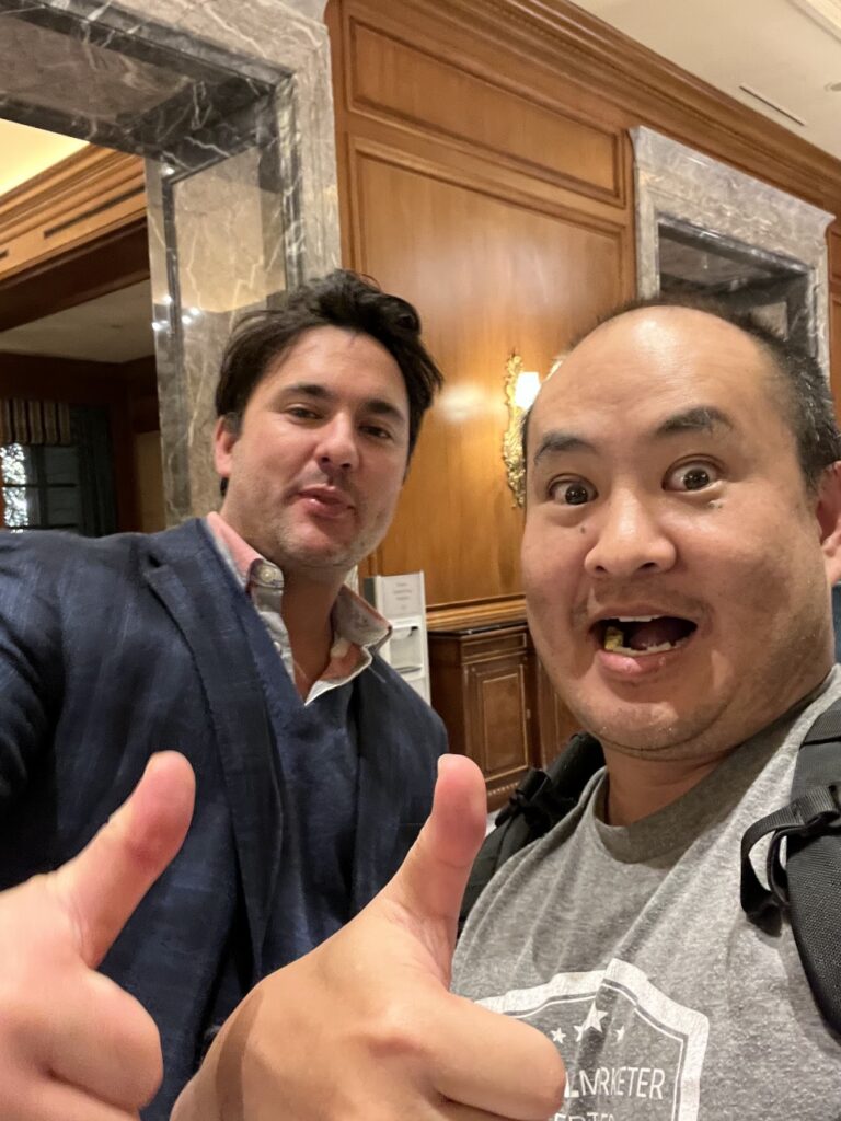 Nathaniel Stevens and Dennis Yu taking a photograph together indoors